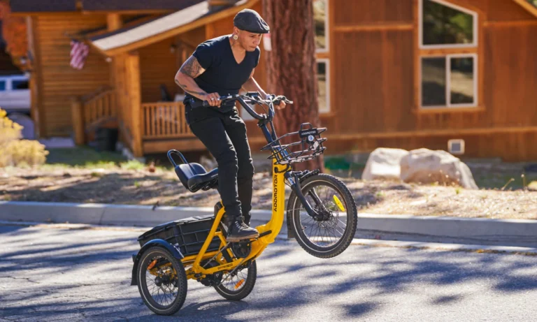 Addmotor CityTri E-310 riding on the street, popping a wheelie