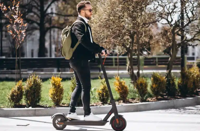 How To Ride An Electric Scooter - A Man Riding An Electric Scooter Outside.